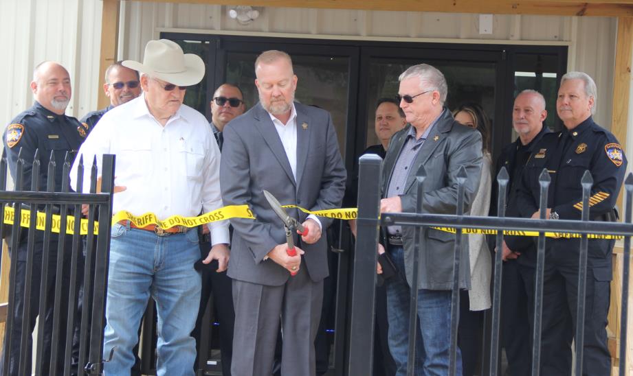 Left to right: Sheriff Tommy Gage, Sheriff Rand Henderson, Sheriff Guy Williams cutting the ribbon (crime scene tape) to the new Sheriff Museum. Museum Committee pictured in the background.